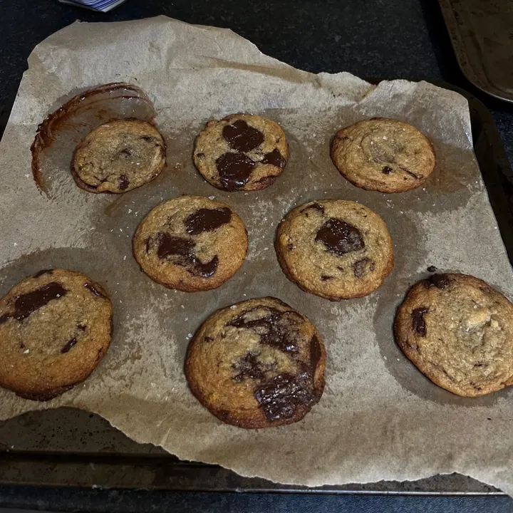 Dark chocolate and sea salt cookies on baking parchment