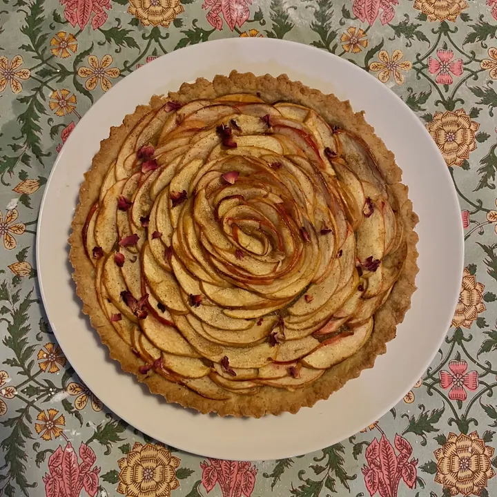 Apple rose tart from above on a floral tablecloth