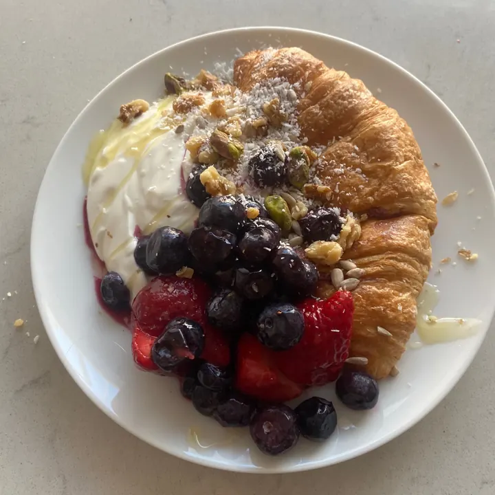 A croissant loaded with yoghurt, berries and nuts