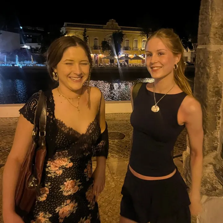 Two friends at night by the waterfront in Portugal