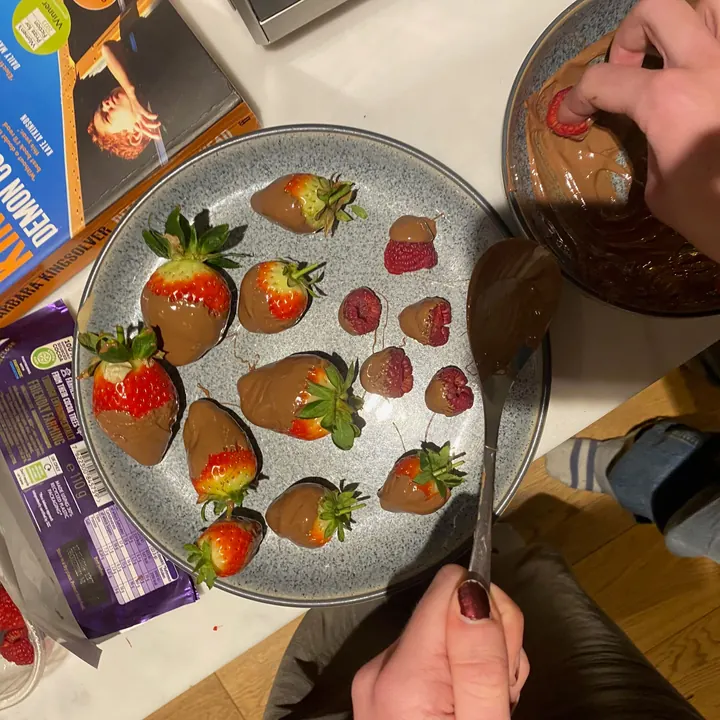 Dipping strawberries and raspberries in melted chocolate