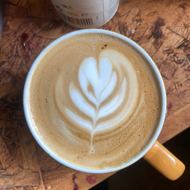Latte art in a cup with a yellow handle at Sheppard’s Cafe