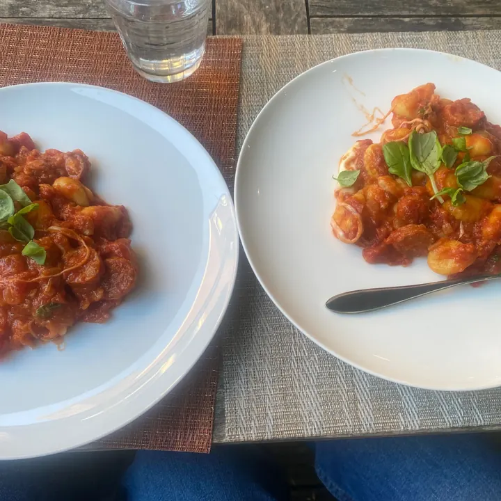 Two bowls of chorizo and mozzarella gnocchi with basil